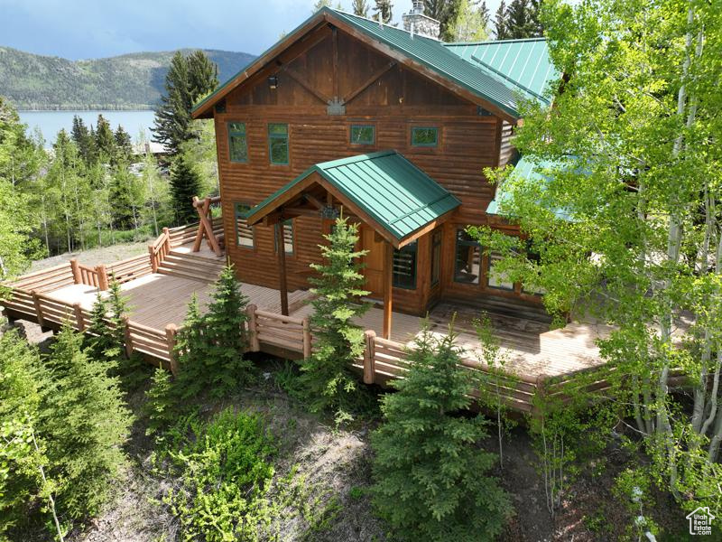 Rear view of house with a standing seam roof, metal roof, and a deck with water view