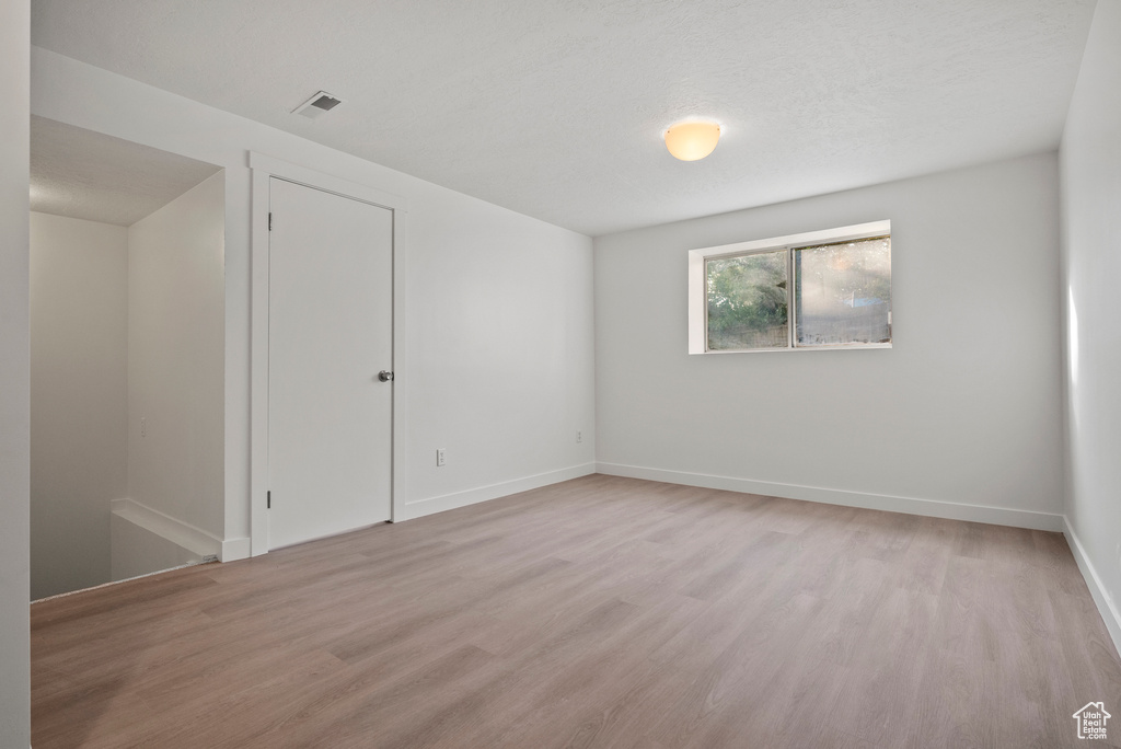 Empty room with light wood-style flooring and baseboards