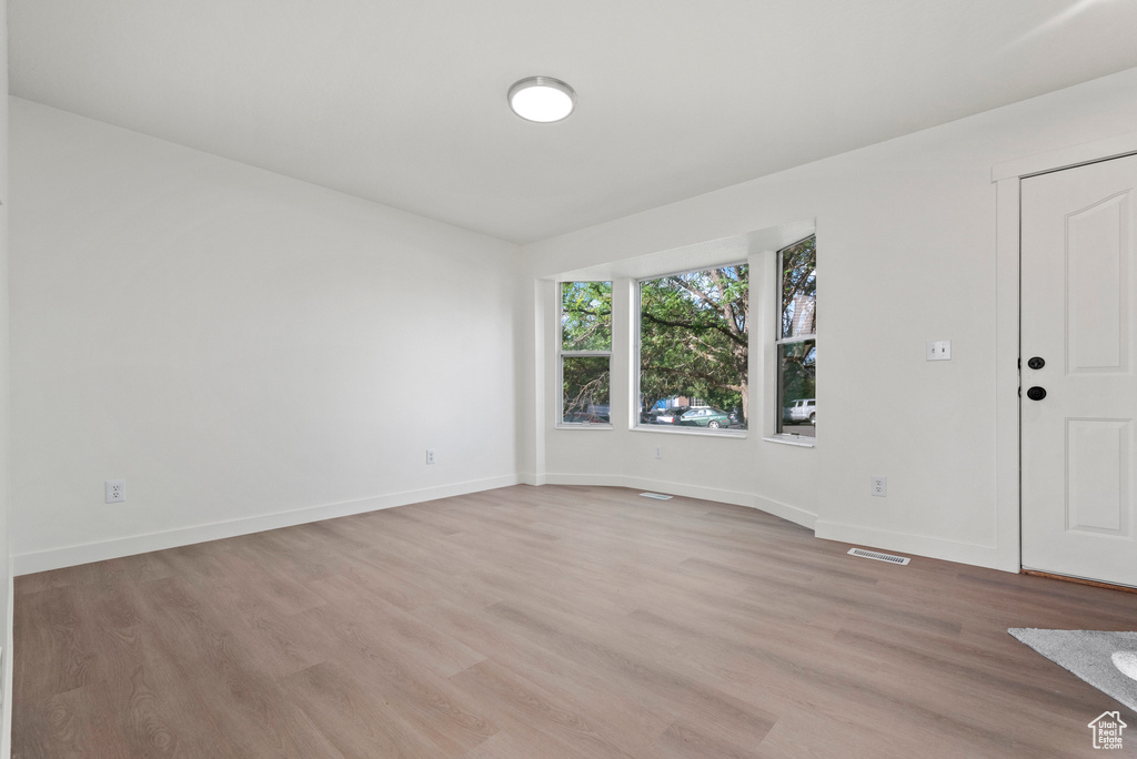 Spare room featuring light wood finished floors and baseboards