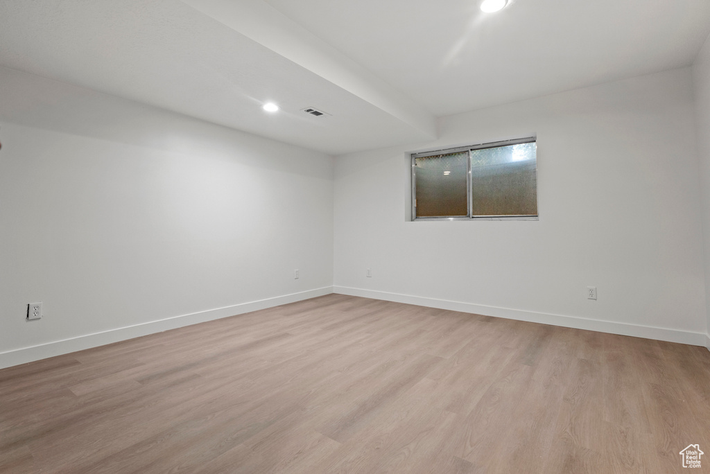 Spare room featuring light wood-style flooring, baseboards, and recessed lighting