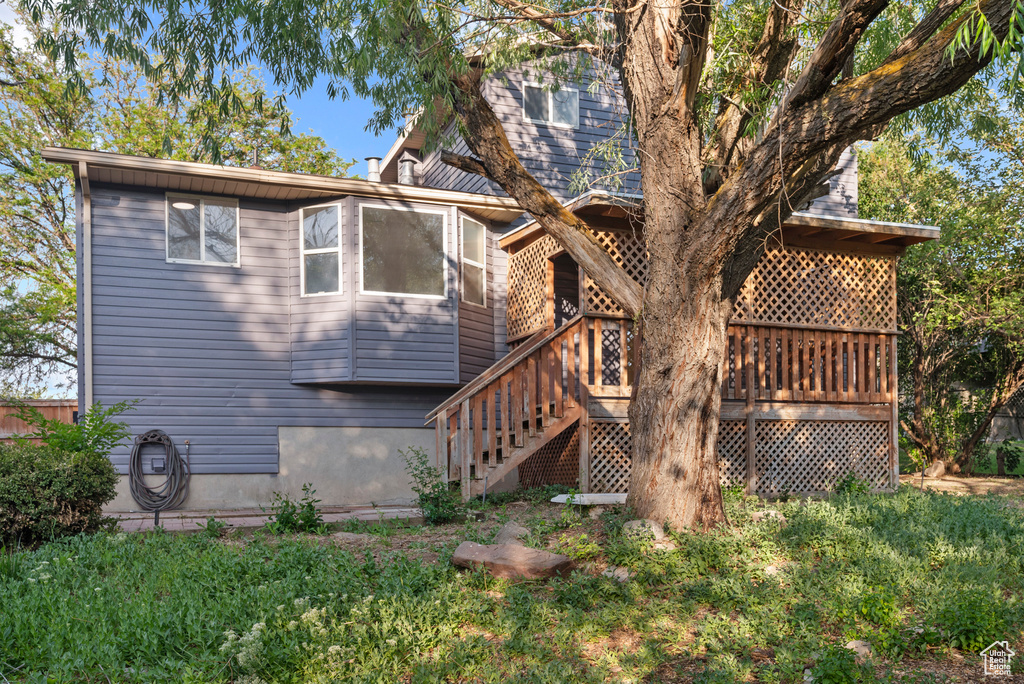 View of side of home featuring a deck and stairs