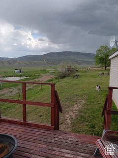 Wooden deck featuring a rural view and a mountain view