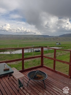 Deck featuring a fire pit and a water and mountain view