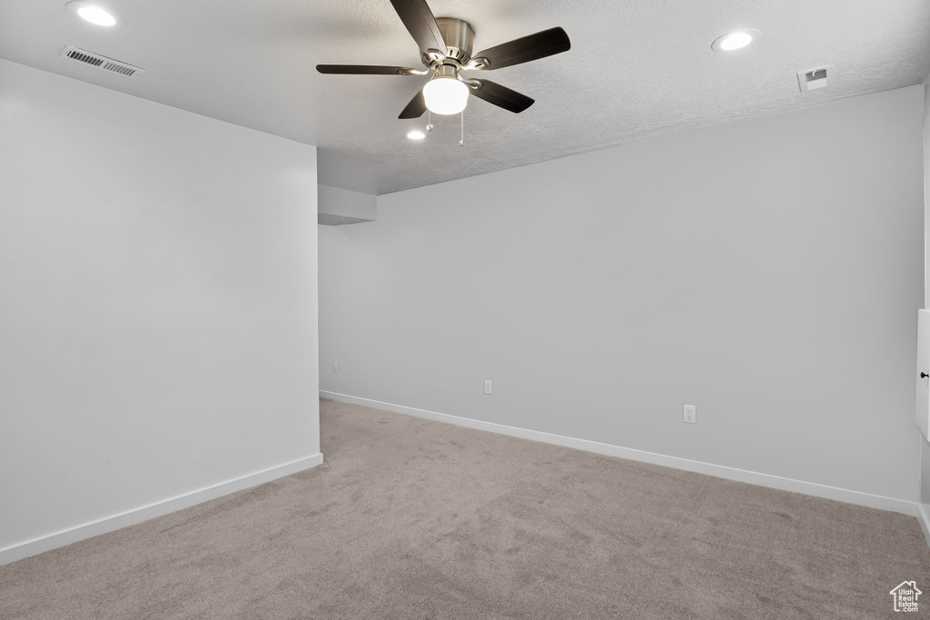 Carpeted spare room with ceiling fan, baseboards, and recessed lighting