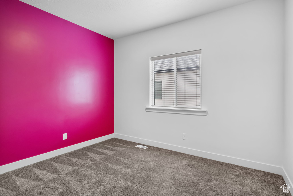 Carpeted empty room with baseboards