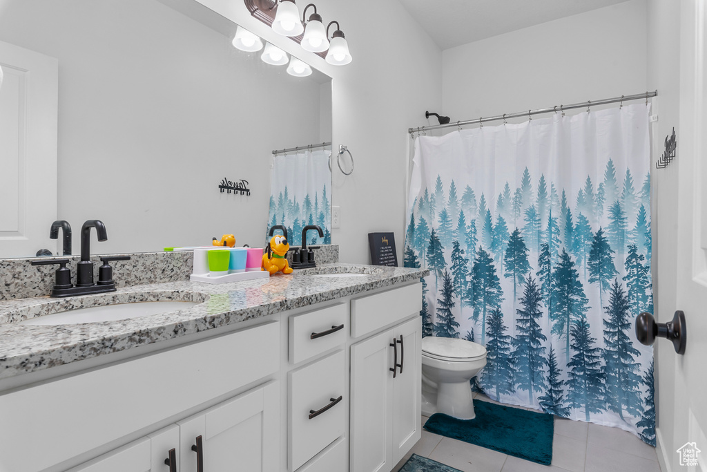 Full bathroom with tile patterned flooring, double vanity, toilet, and a shower with shower curtain