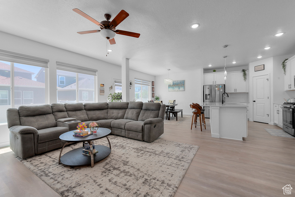 Living room featuring recessed lighting, ceiling fan, and light wood-type flooring