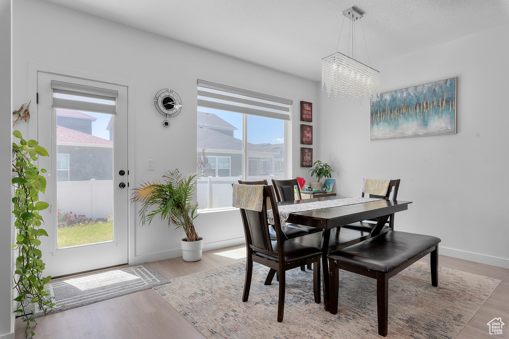 Dining area featuring a chandelier, wood finished floors, and baseboards
