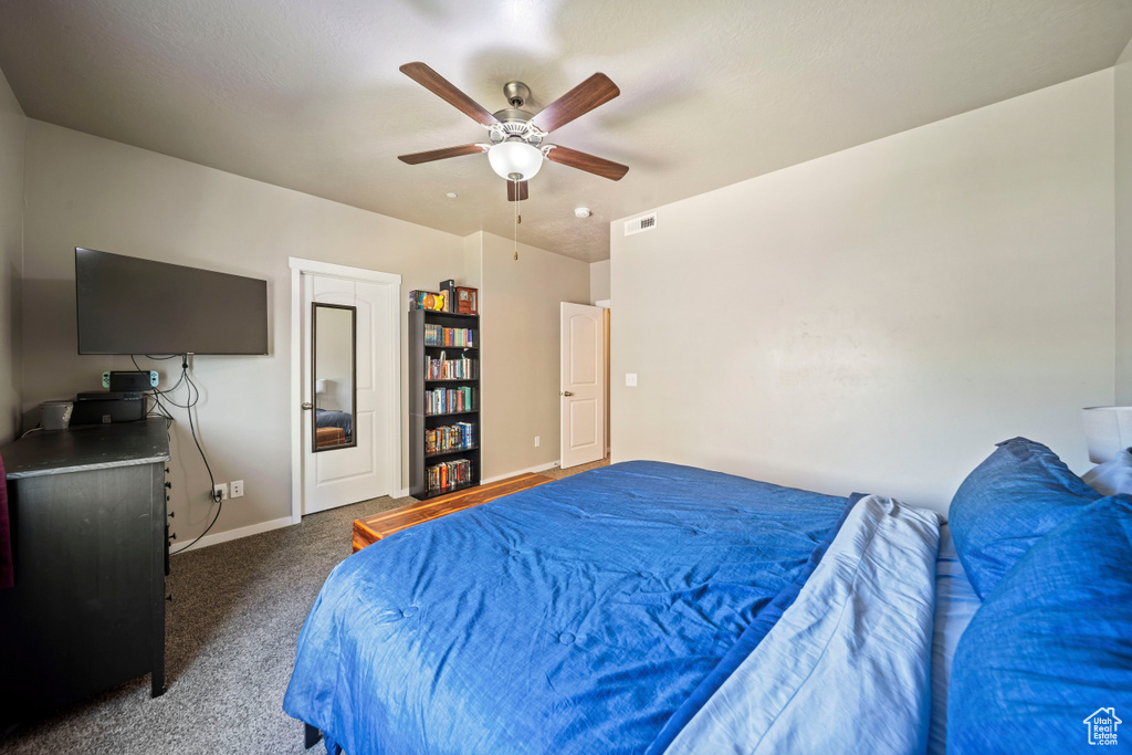 Carpeted bedroom featuring baseboards and ceiling fan
