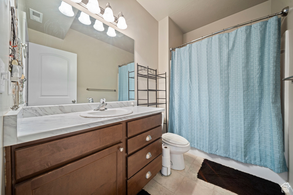 Full bath featuring toilet, vanity, and tile patterned floors