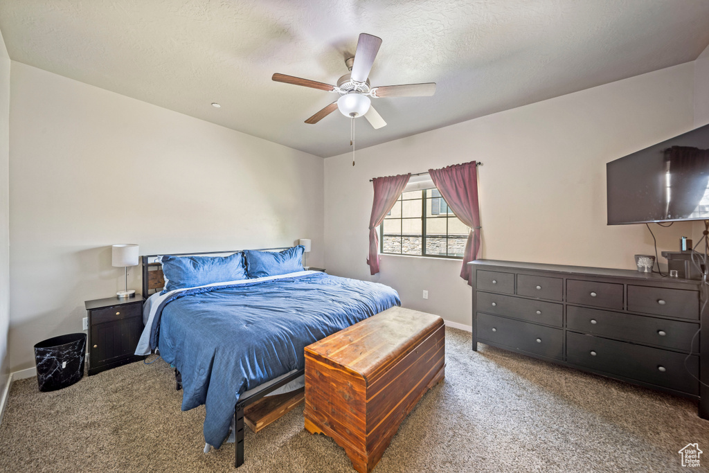 Bedroom featuring carpet floors, baseboards, and ceiling fan