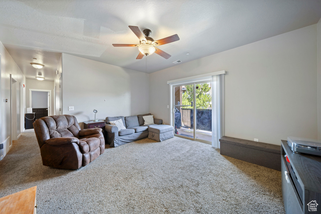 Living room with carpet flooring and a ceiling fan