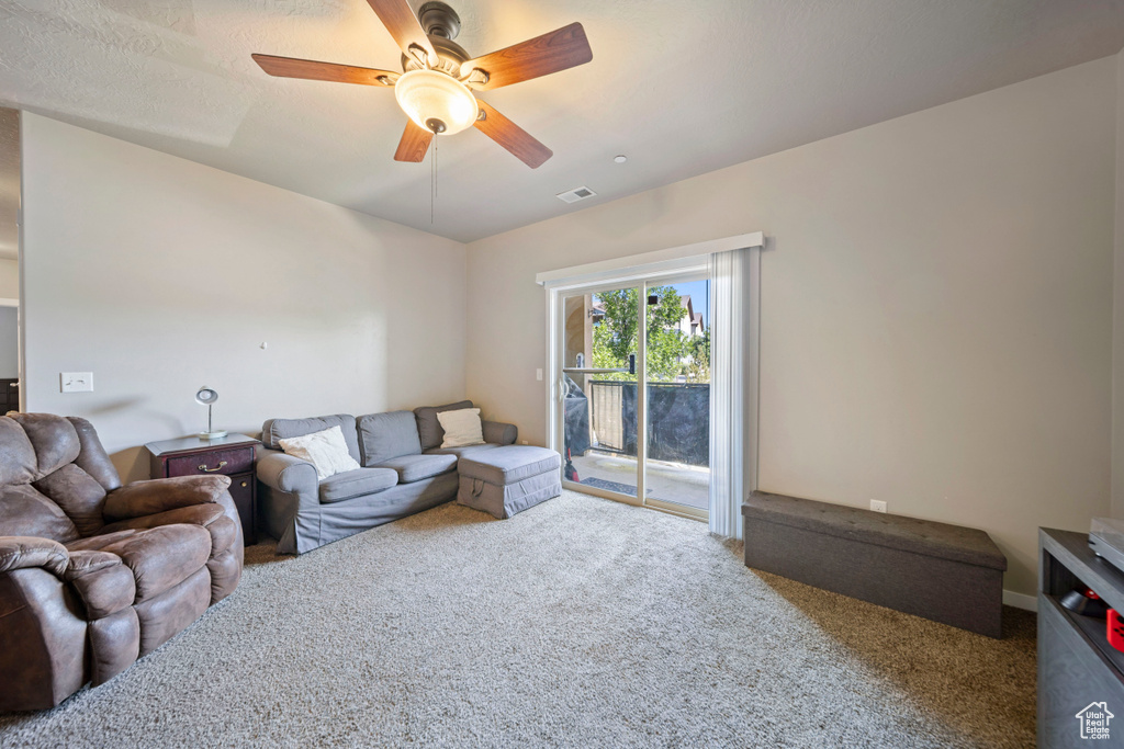 Living area featuring carpet flooring and ceiling fan