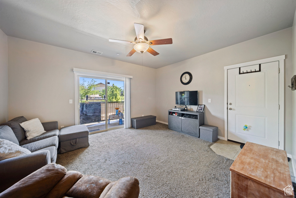 Living area with ceiling fan, carpet floors, and baseboards