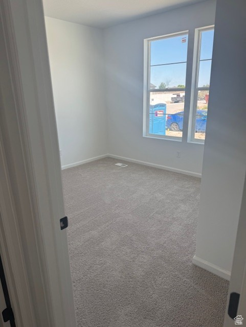 Carpeted empty room with baseboards