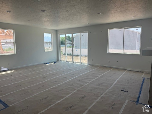 Spare room featuring a textured ceiling and baseboards