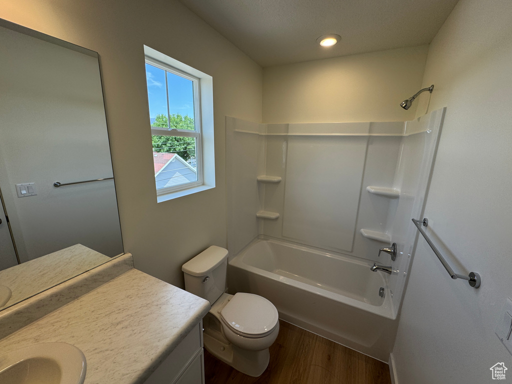 Full bathroom featuring wood finished floors, vanity, bathtub / shower combination, and recessed lighting