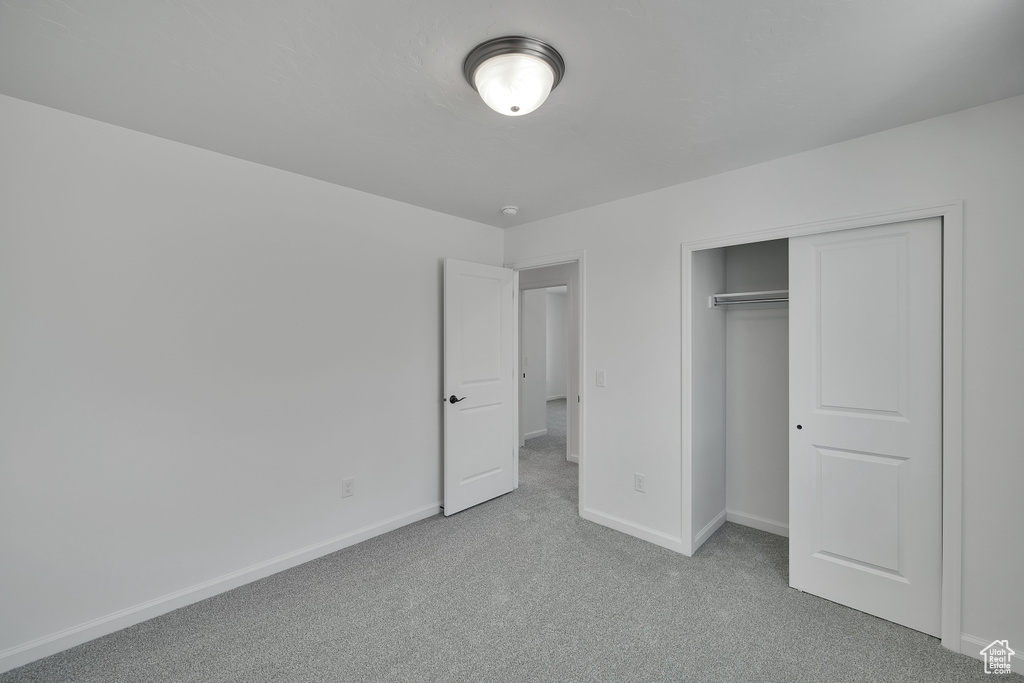 Unfurnished bedroom with carpet, baseboards, and a closet