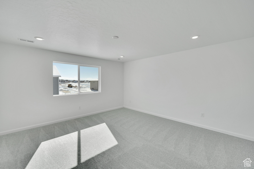 Carpeted spare room featuring baseboards and recessed lighting