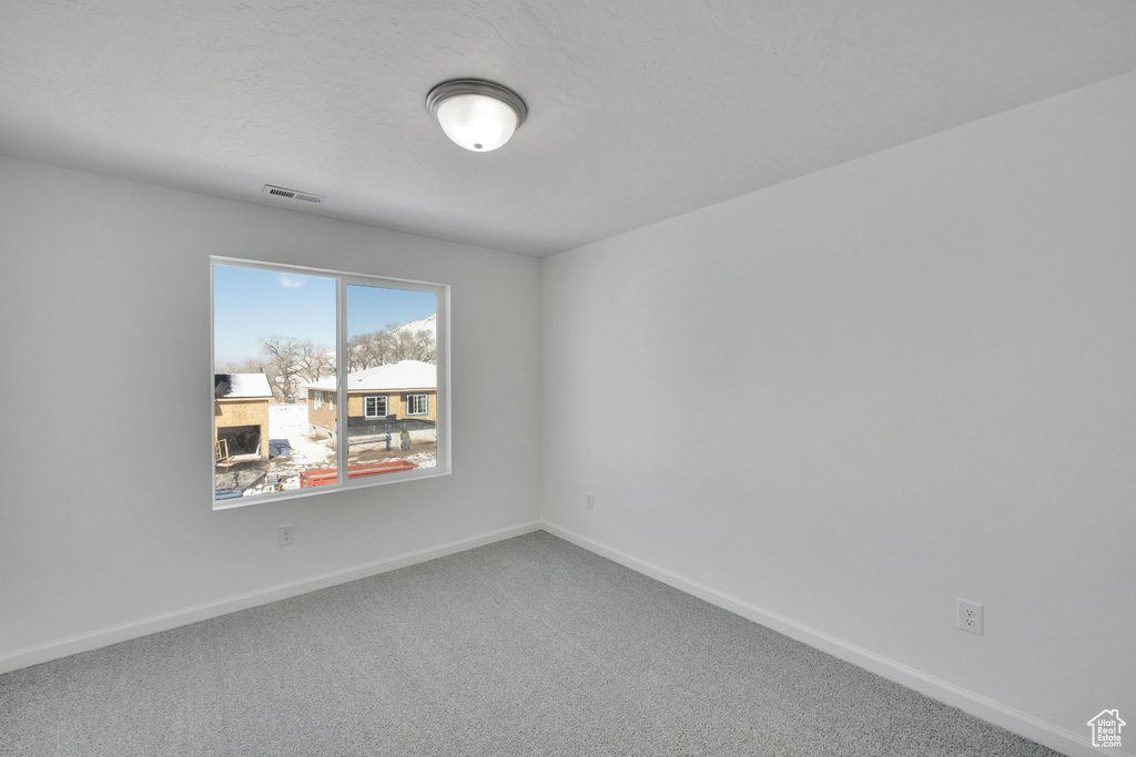Carpeted spare room with baseboards