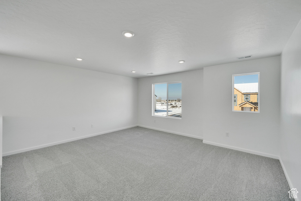 Carpeted empty room featuring baseboards, healthy amount of natural light, and recessed lighting