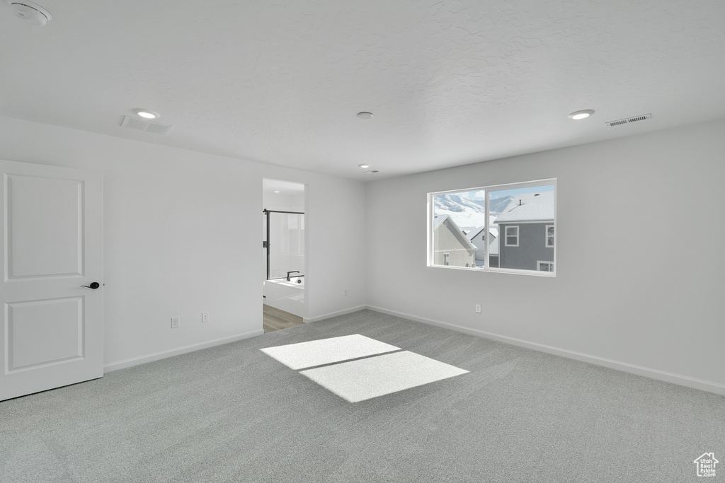 Spare room featuring carpet floors, baseboards, and recessed lighting
