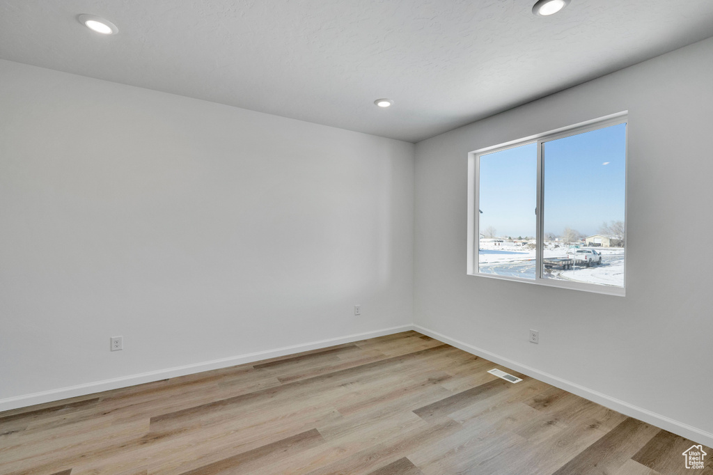 Unfurnished room with light wood-style floors, baseboards, and recessed lighting