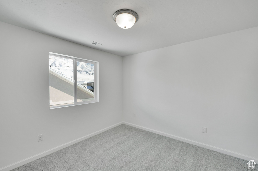 Carpeted empty room with baseboards