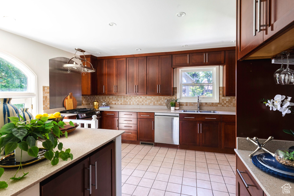 Kitchen featuring stainless steel appliances, a sink, light countertops, and backsplash