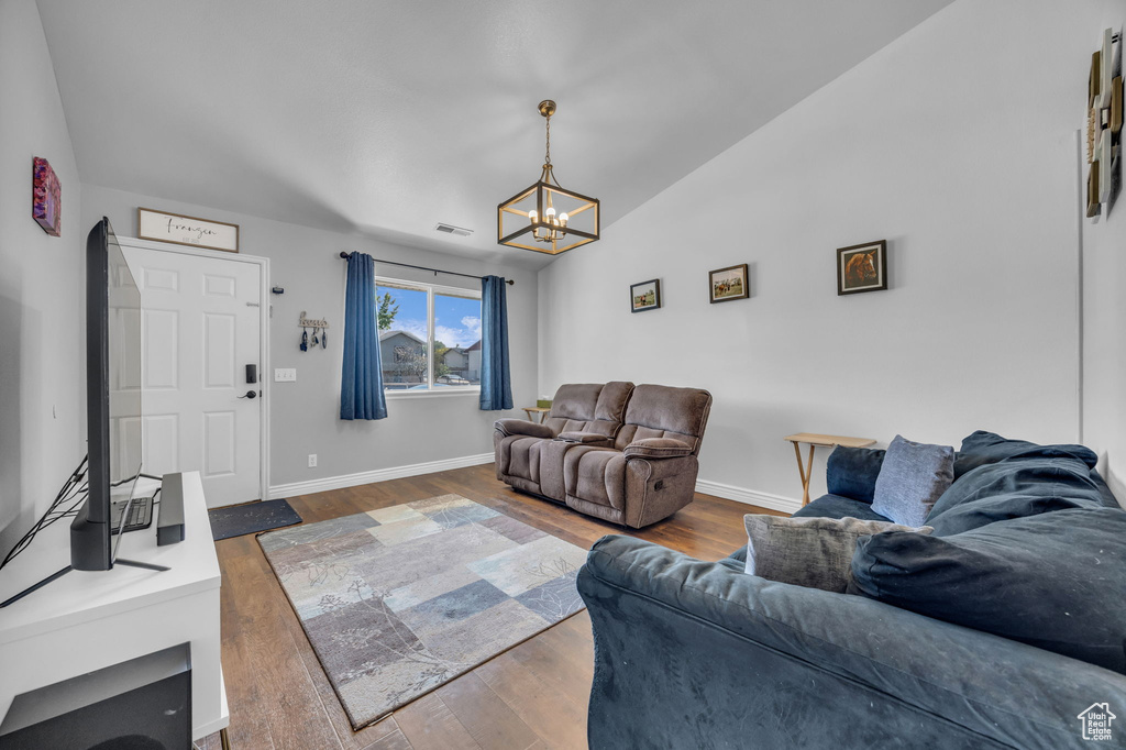 Living area featuring a chandelier, wood finished floors, and baseboards
