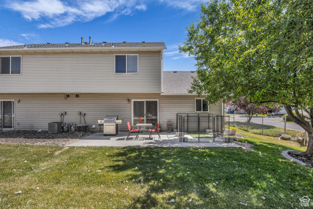 Back of property with a patio area, central AC, and a shingled roof