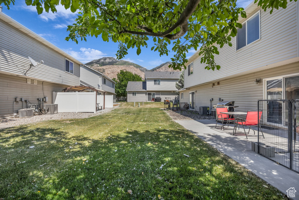 View of yard with a mountain view, a patio, and central AC unit