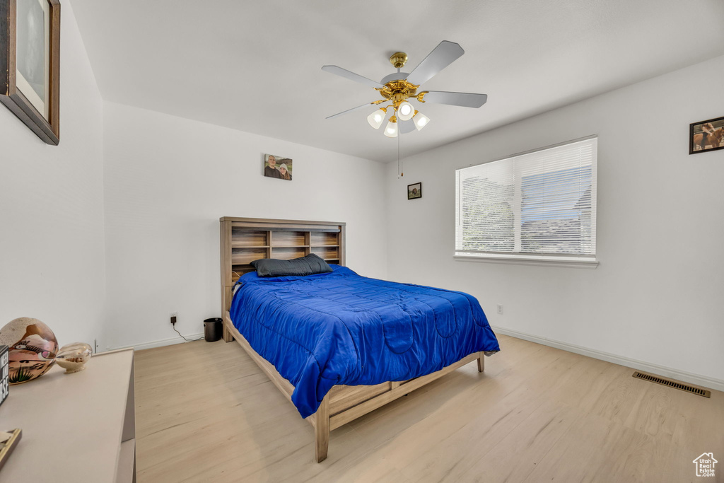 Bedroom with wood finished floors, baseboards, and a ceiling fan