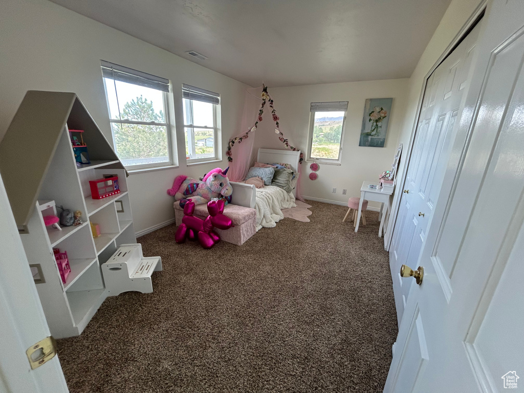 Bedroom featuring carpet and baseboards