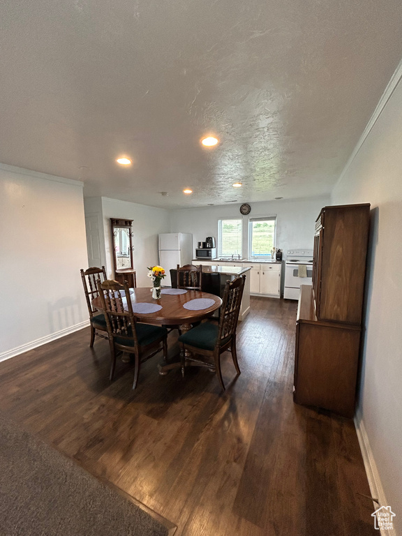 Dining space featuring dark wood-type flooring, baseboards, and recessed lighting