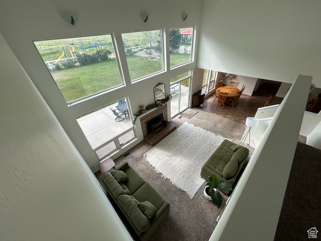 Living area featuring a high ceiling and a fireplace with raised hearth