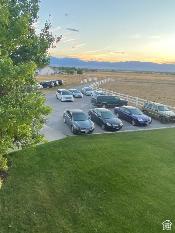 Parking at dusk featuring uncovered parking and a mountain view