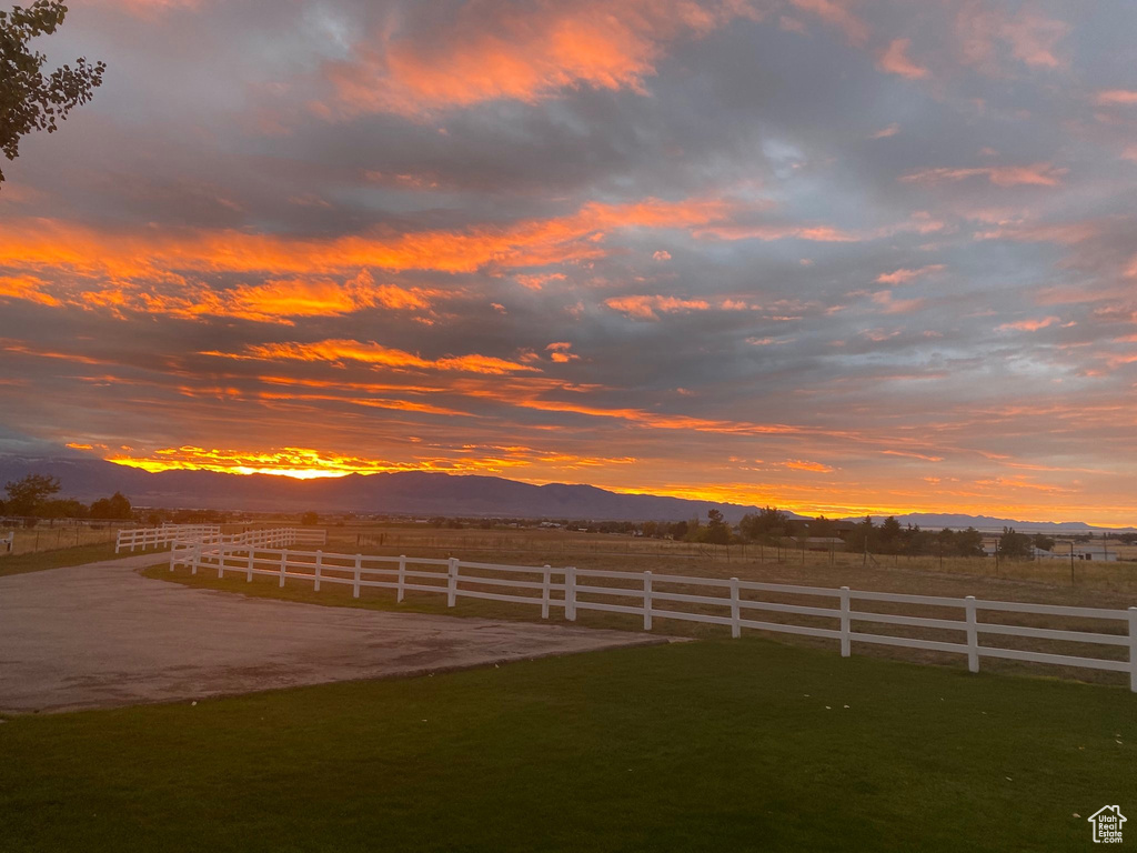Yard at dusk with a view of rural / pastoral area and a mountain view