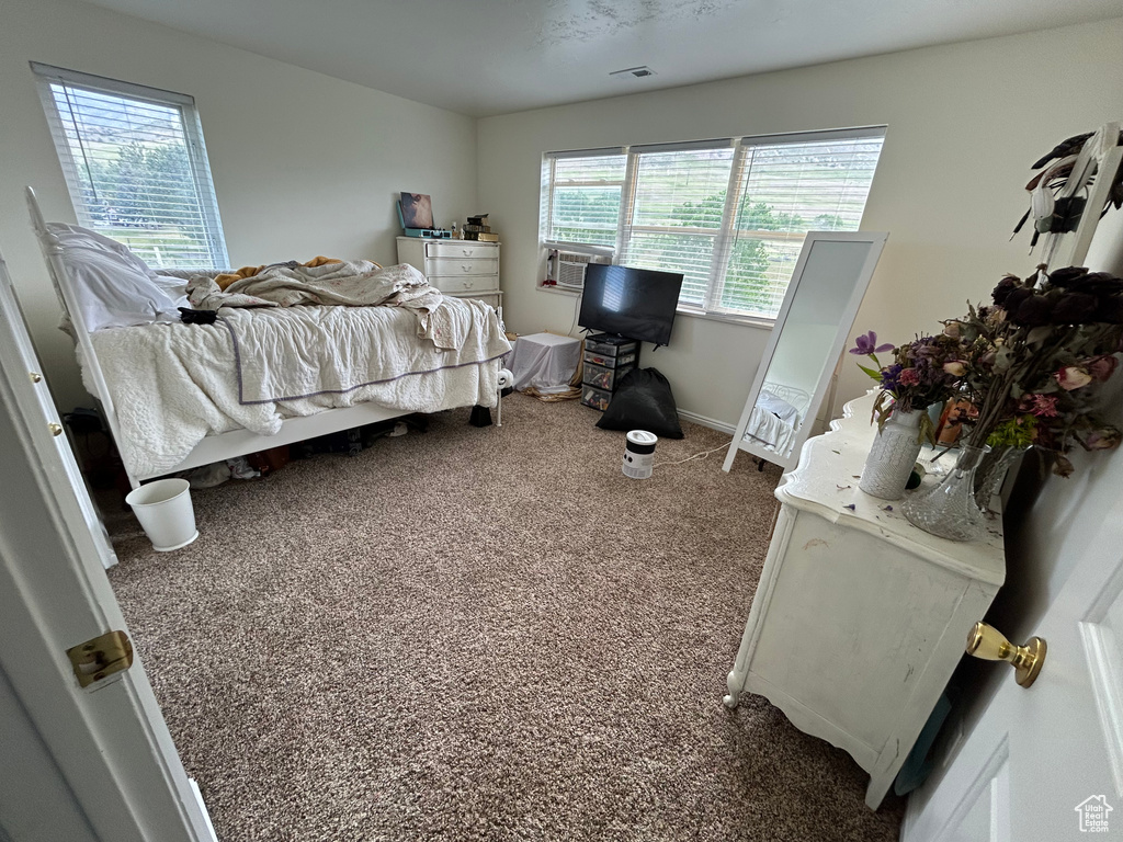 Carpeted bedroom featuring cooling unit and baseboards