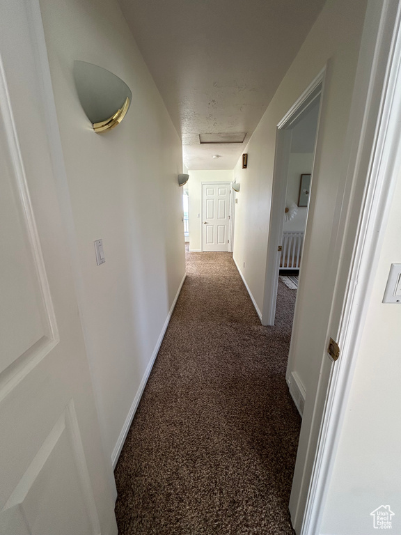 Corridor with baseboards and attic access