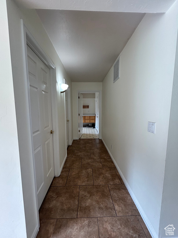 Hall featuring baseboards and tile patterned flooring