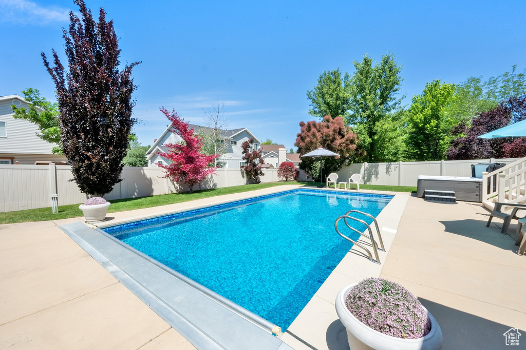 View of swimming pool with a patio area and a fenced backyard