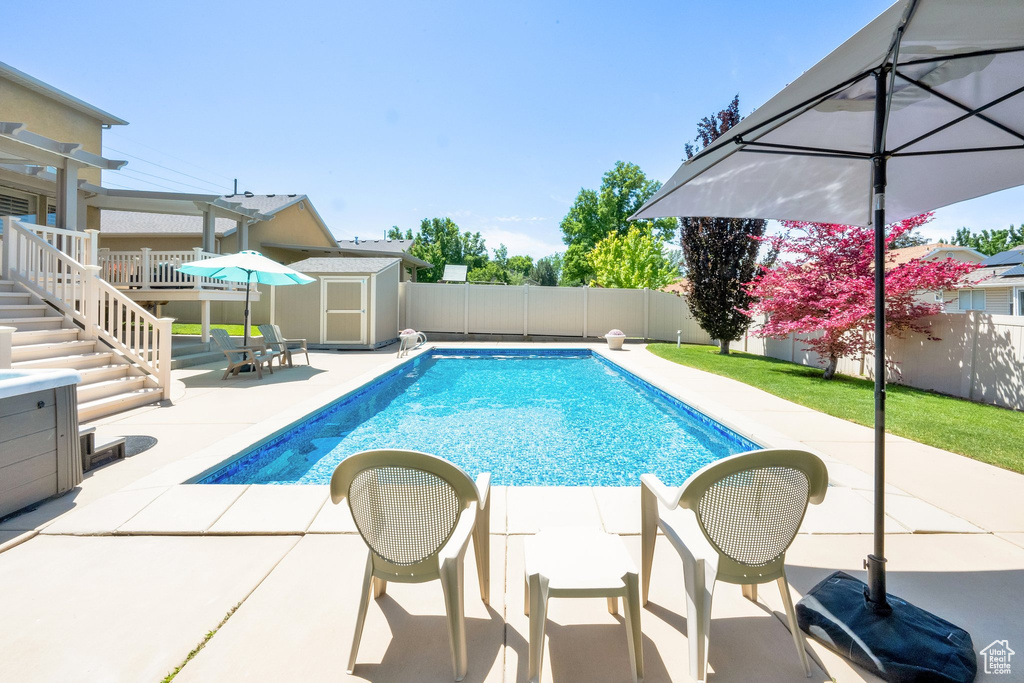 View of swimming pool with a patio area, a fenced backyard, and stairs