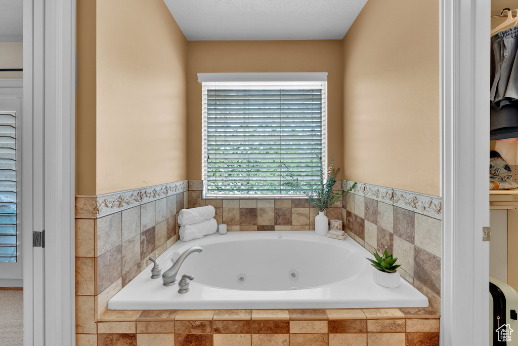 Bathroom with a whirlpool tub and a spacious closet