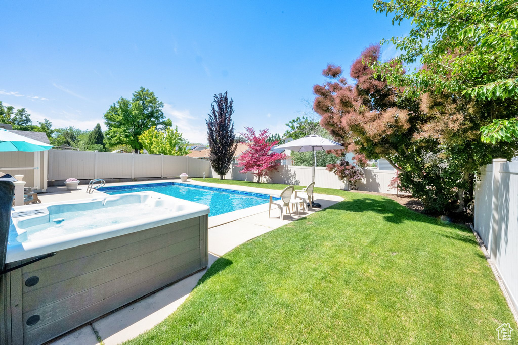 View of pool with a hot tub and a patio