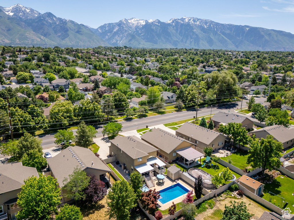 Aerial perspective of suburban area featuring a pool area and a mountainous background