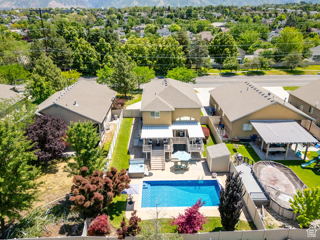 Aerial view of residential area with a pool and a mountainous background