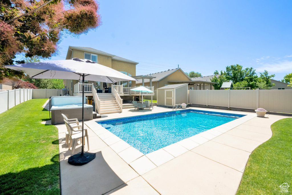 View of pool featuring a hot tub, a deck, a patio, and stairway