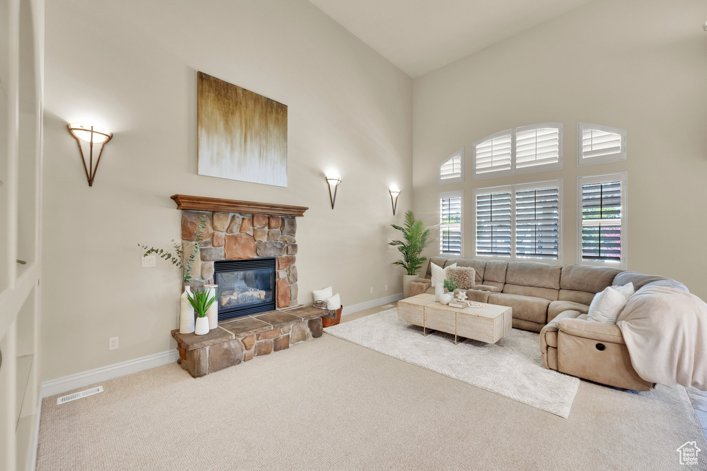 Living area featuring carpet, a fireplace, high vaulted ceiling, and baseboards