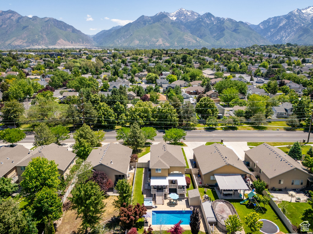 Aerial perspective of suburban area featuring a pool and mountains